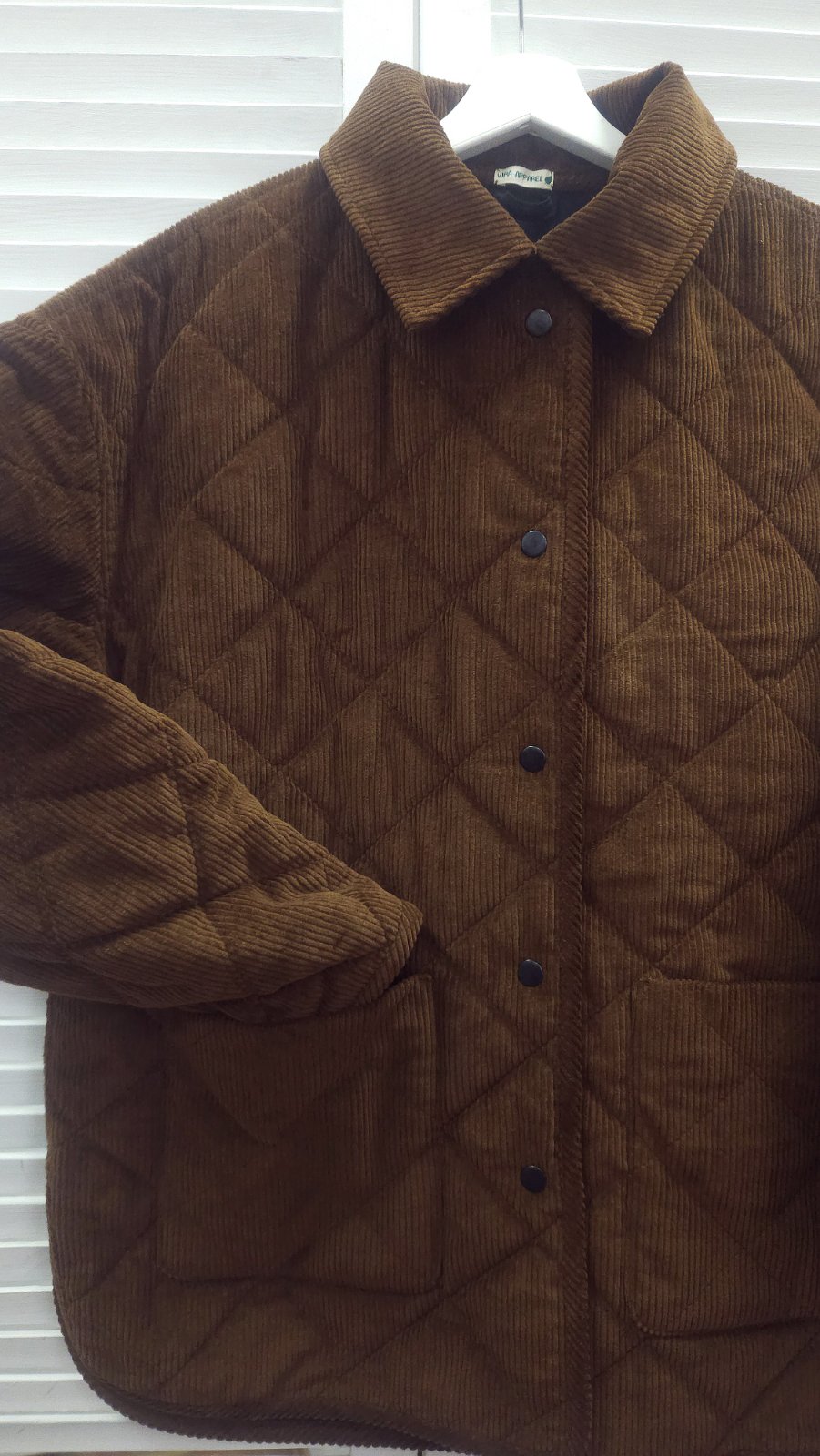 Women’s fall outfit featuring a quilted corduroy jacket with wooden buttons and wide leg trousers