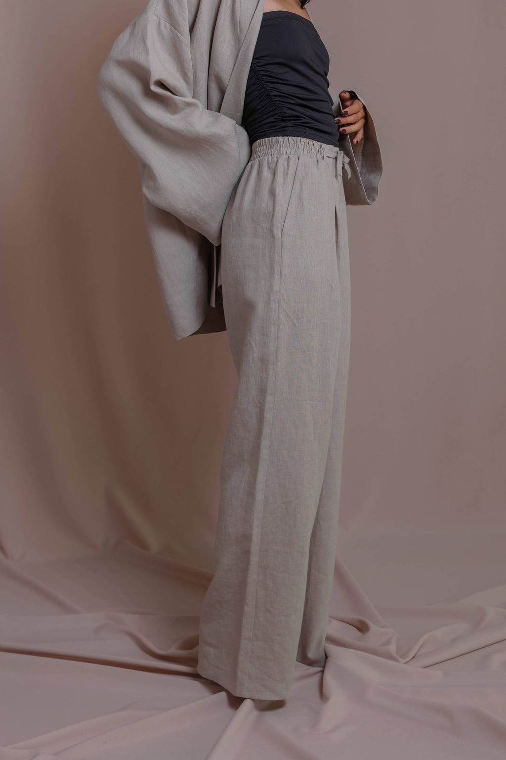 Light gray Casual linen pants showing pocket detail and relaxed wide silhouette.