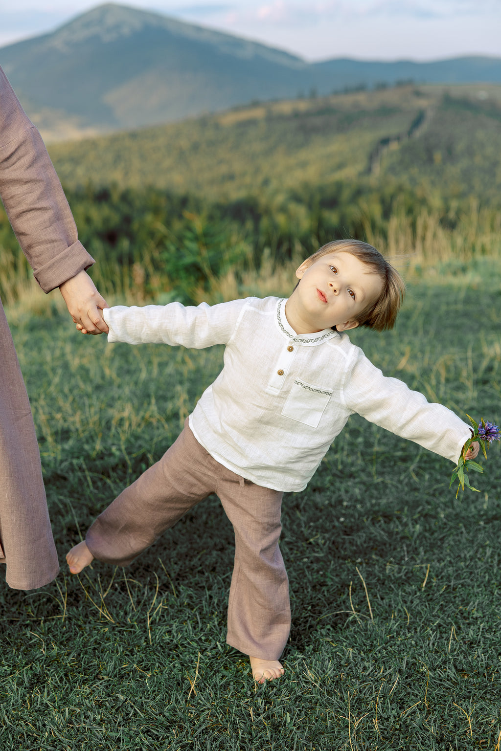Minimalist embroidered boys’ linen shirt, soft breathable fabric, white shirt with green stitching, stylish toddler clothing.
