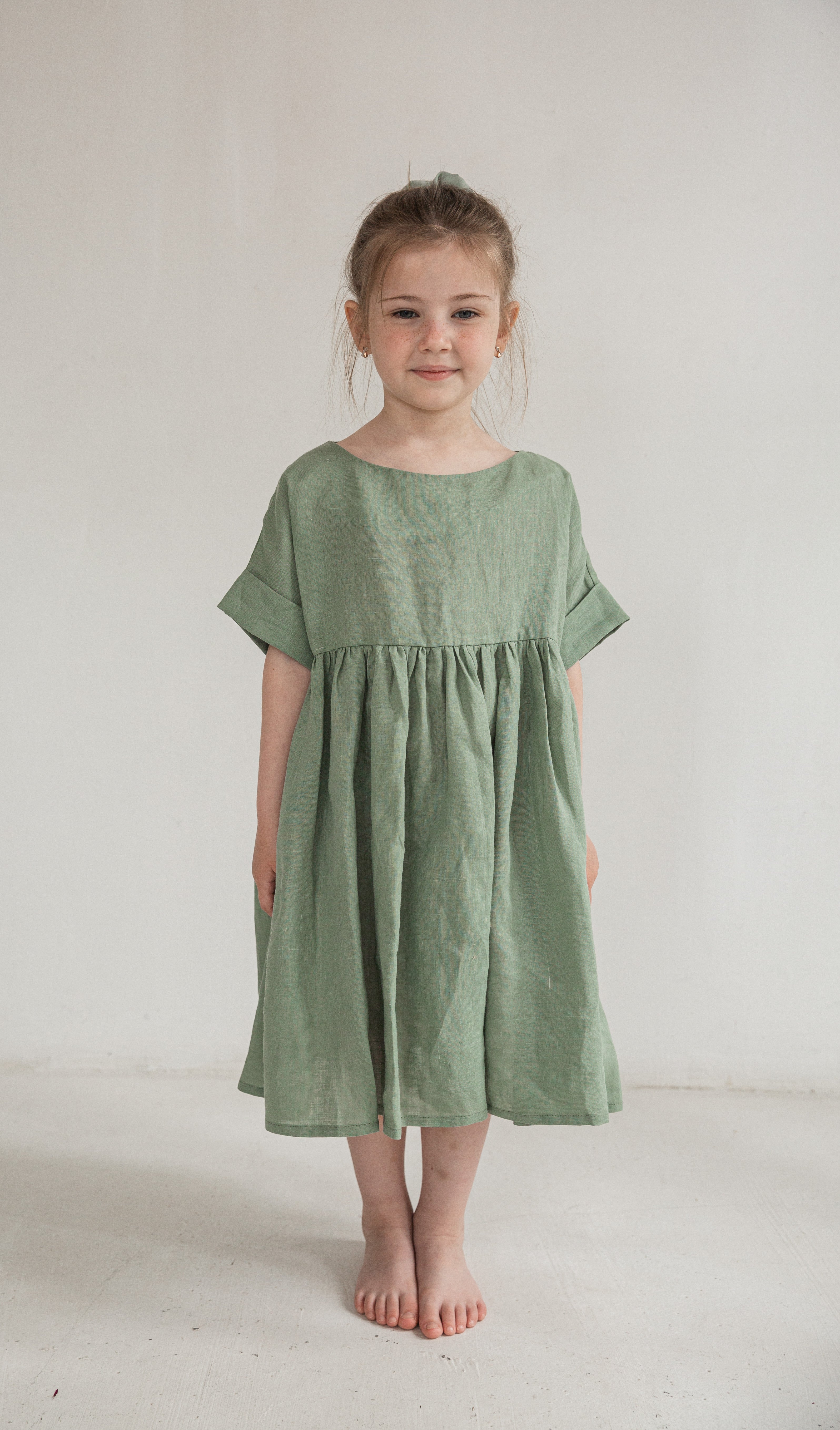 Side view of a child in an eco friendly ramie dress, lightweight nettle fabric kids clothing