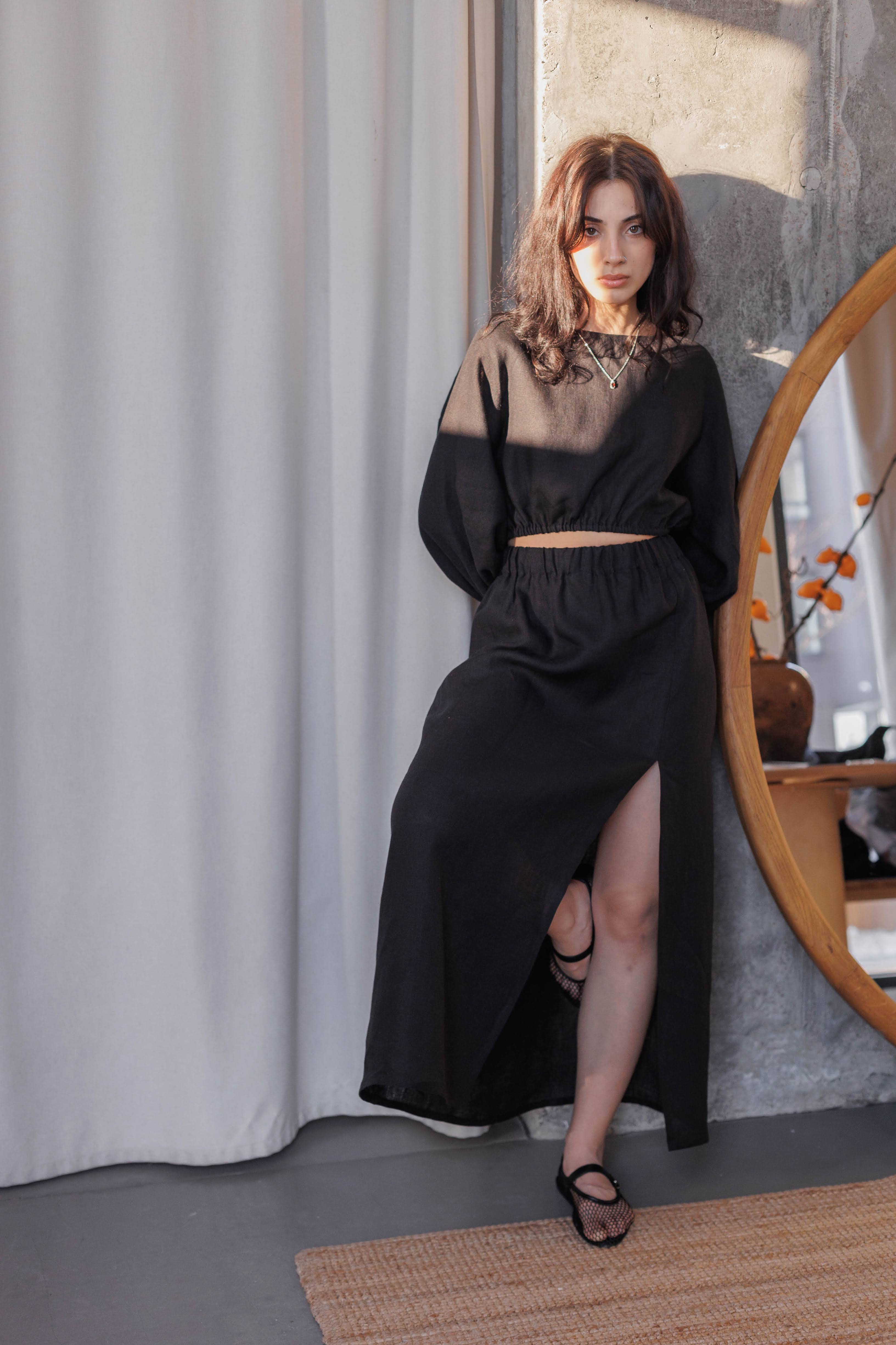 Black A-line linen skirt with elasticated waistband and front slit, made from 100% stonewashed linen.