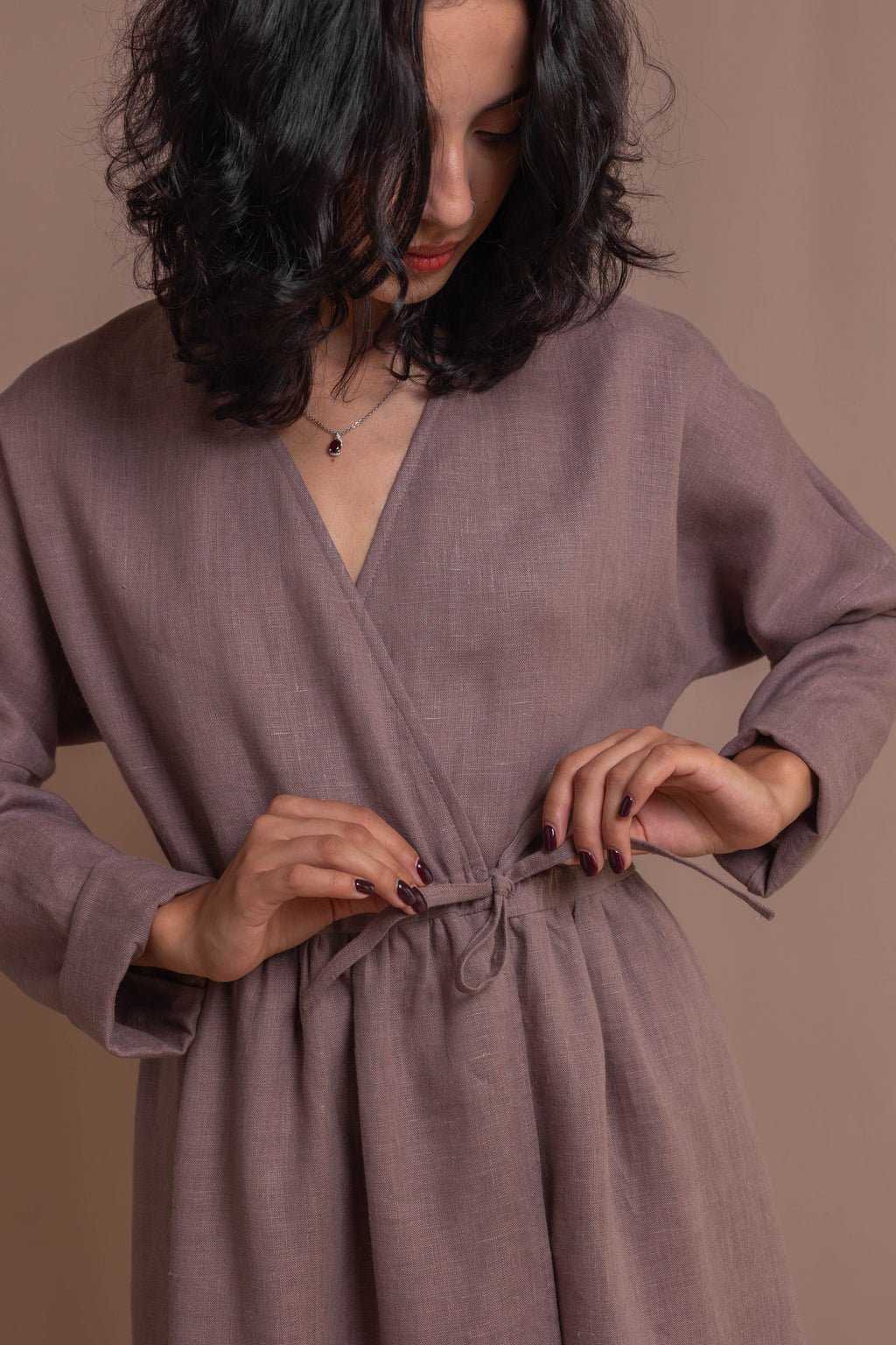 Detail of adjustable waist drawstring on a 100% linen wrap dress