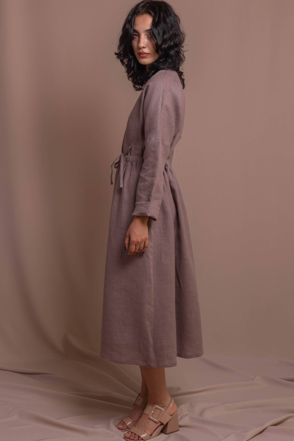 Side view of a 100% linen wrap dress with long sleeves and feminine silhouette