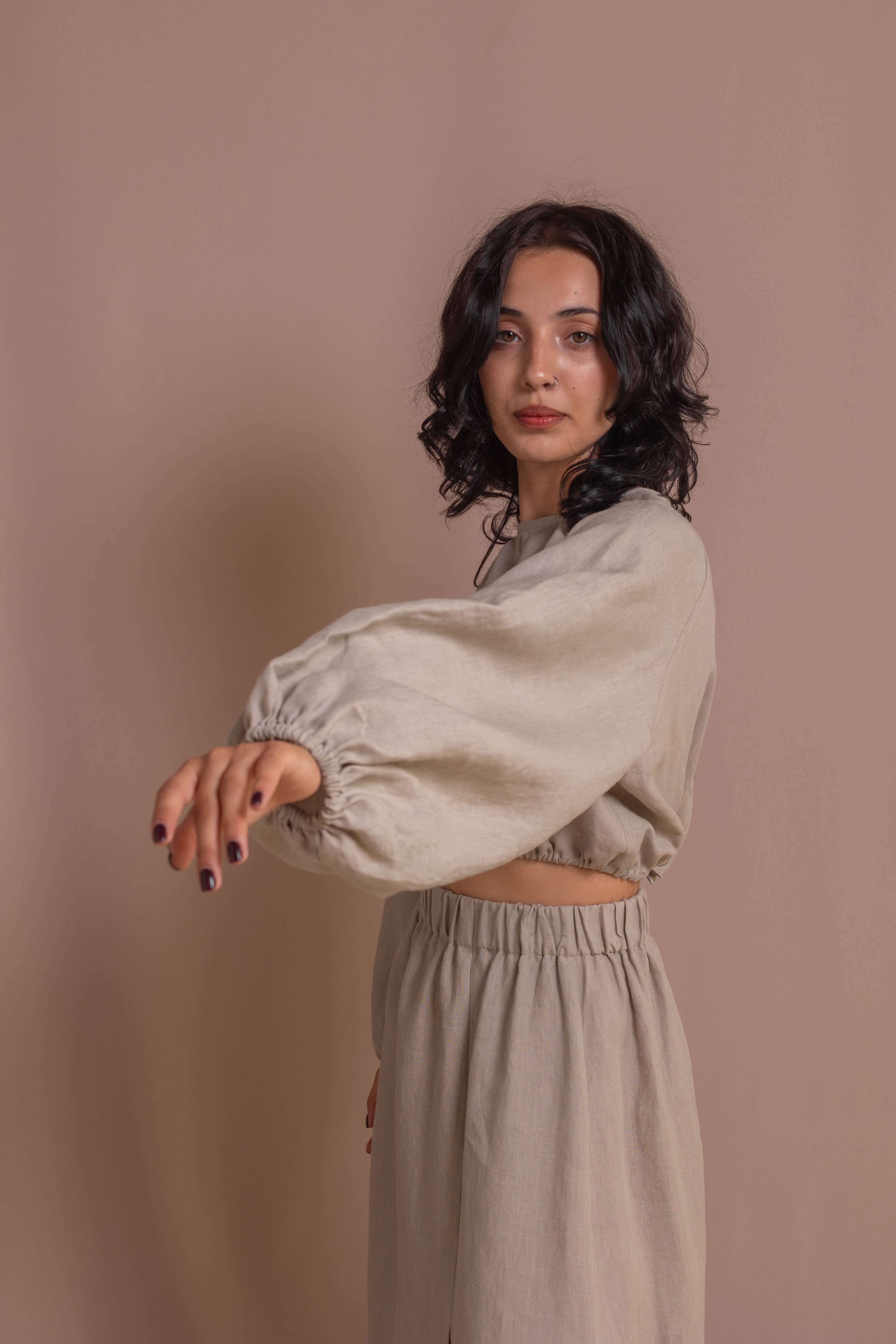 White linen blouse with puff sleeves, natural coconut buttons, and comfortable elasticated hem, handcrafted for effortless style