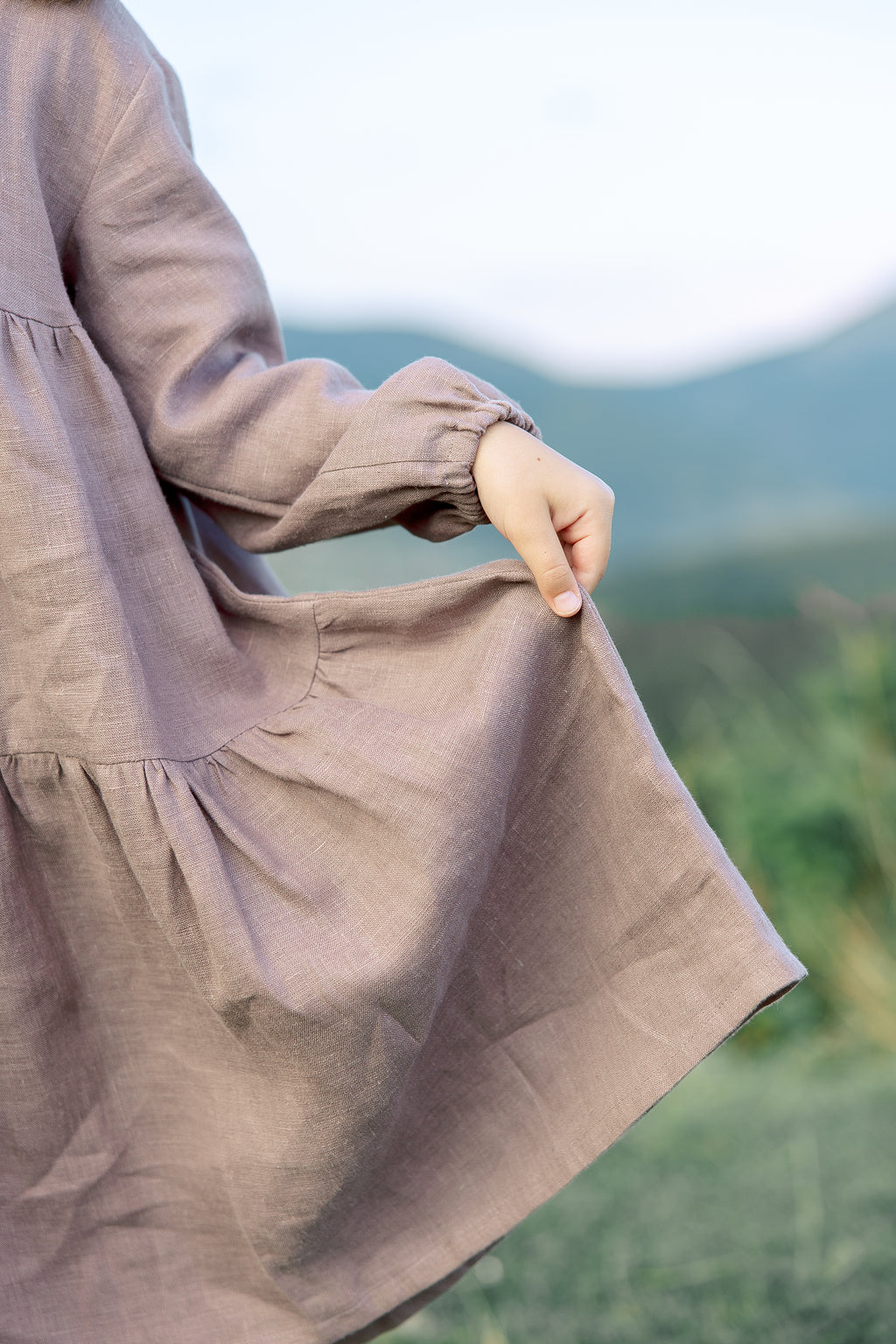 Charming handmade girls’ linen dress with elasticated puff sleeves, flowing skirt, and decorative bow at the back