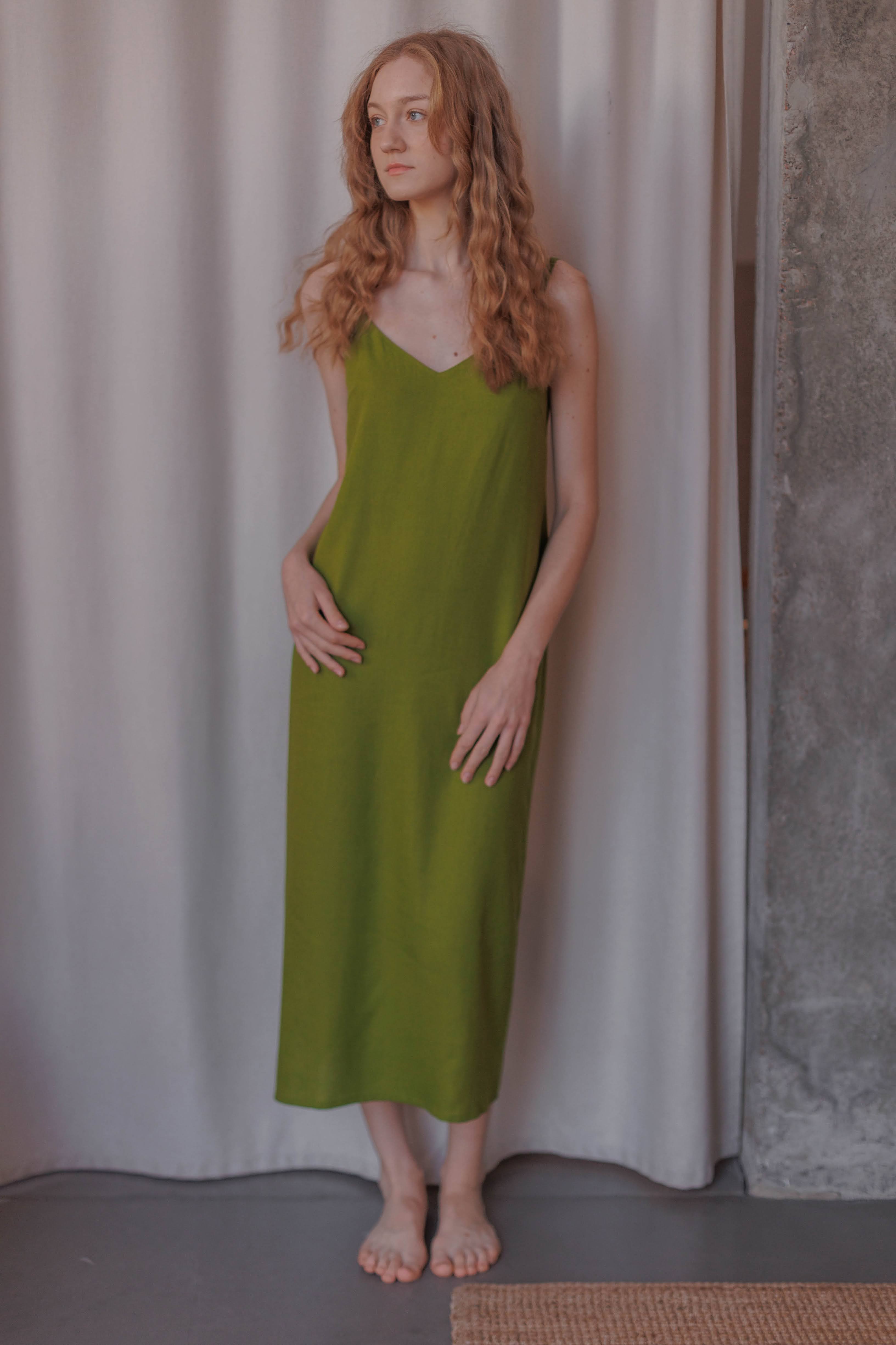 Woman wearing a strappy sundress with open back made from 70% nettle and 30% linen