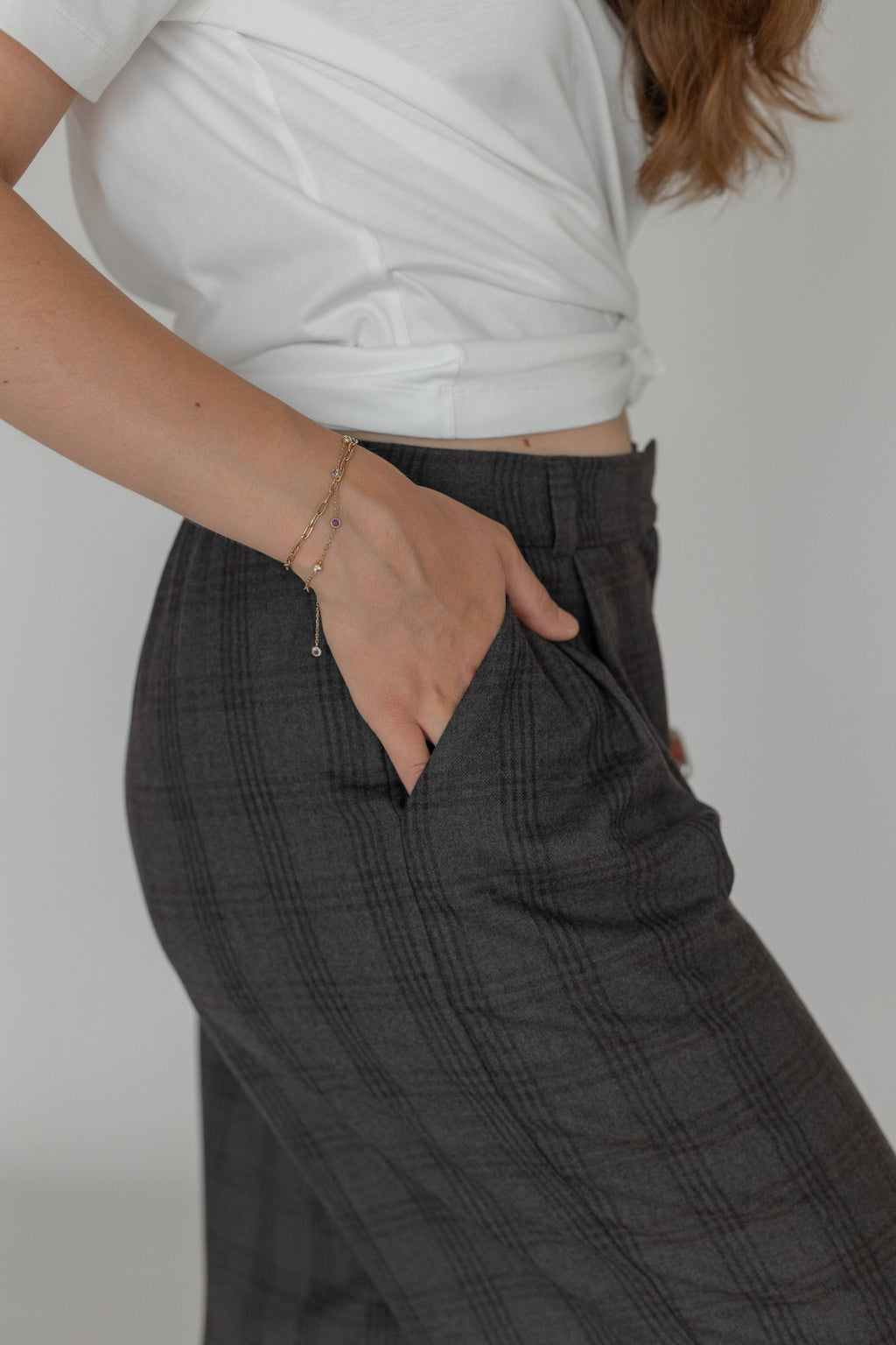 Detail of 100% wool plaid trousers with front pleats